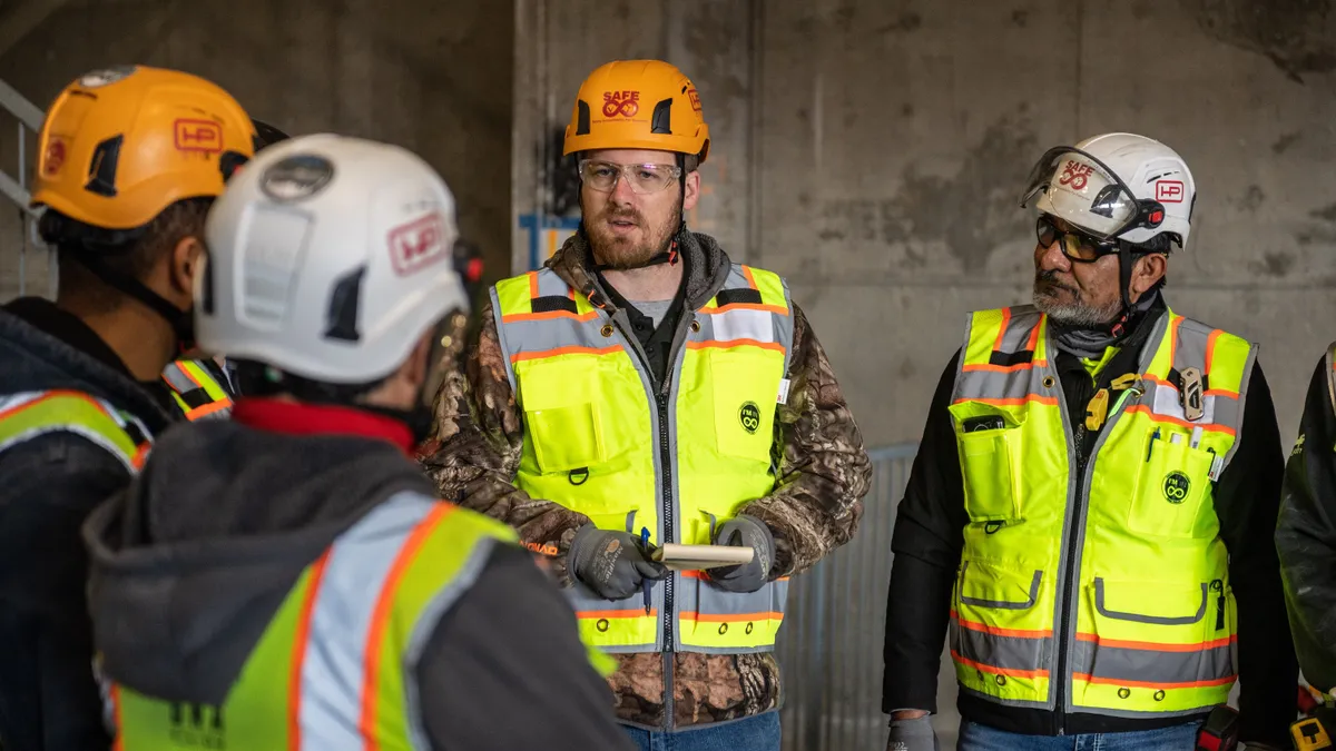 Team of Specialists Use Tablet Computer on Construction Site